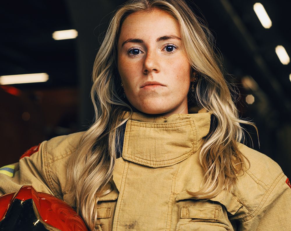 Brandweer vrouw die in de camera kijkt